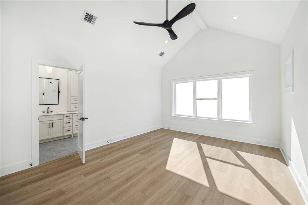 Welcome to the expansive primary retreat situated in the front of the home. This spacious primary includes a ceiling fan, dramatic vaulted ceiling and painted wood ceiling beam offering a decorative element that adds charm to the room