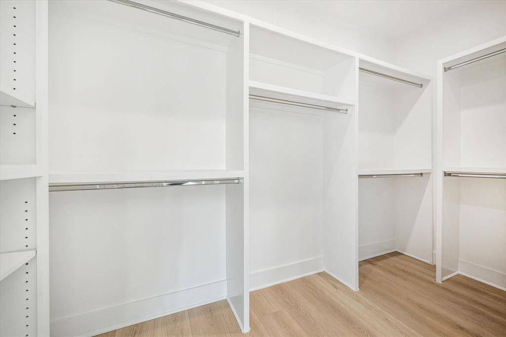 Primary closet with shelves for storage and hanging rods. You will not worry about storage in this home!