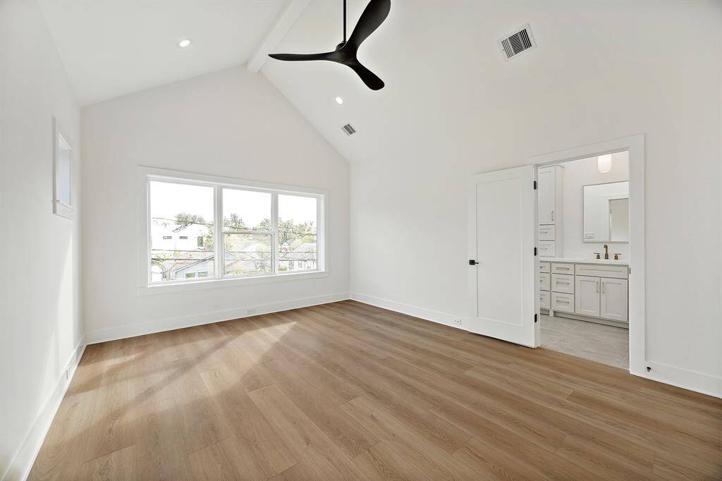 Welcome to the expansive primary retreat situated in the front of the home. This spacious primary includes a ceiling fan, dramatic vaulted ceiling and painted wood ceiling beam offering a decorative element that adds charm to the room