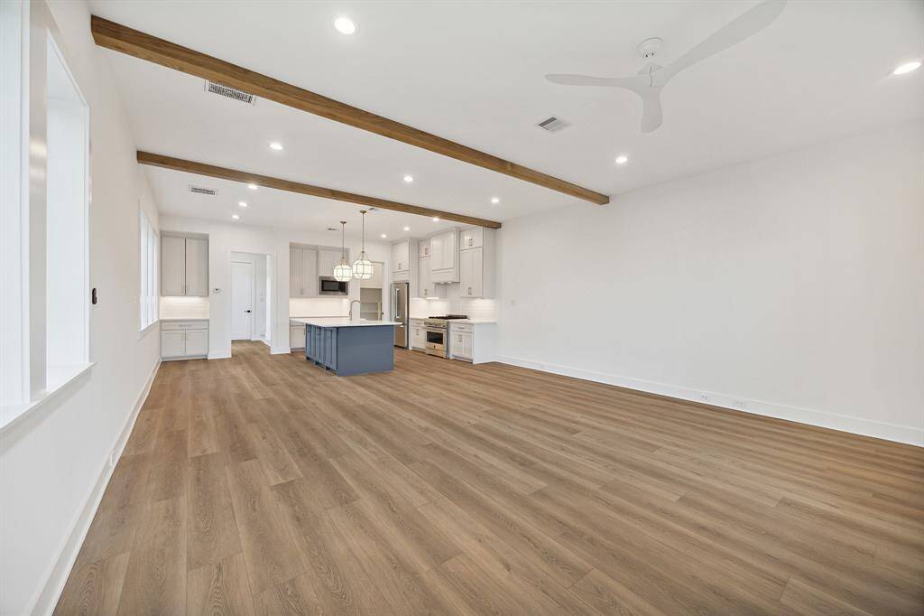 Additional view of the dining room, kitchen, dry bar and wood ceiling beams which add elegance