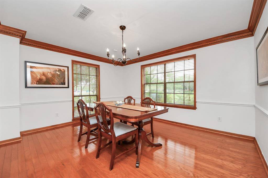 The dining room overlooks both the front and the side of the lushly landscaped exterior, and offers gleaming hardwood flooring and lovely crown molding!