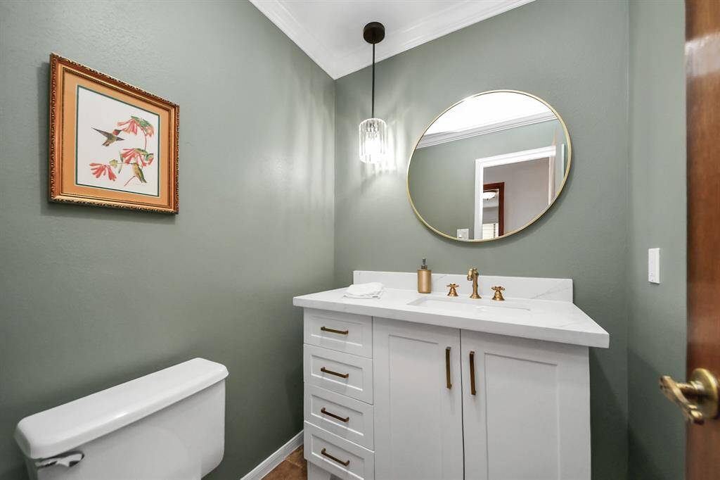 The half bath has been nicely updated with modern cabinetry and fixtures, which include a beautiful pendant light!