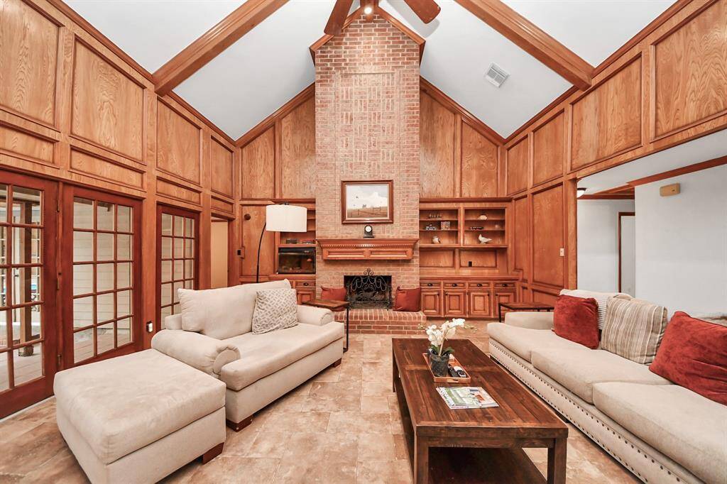 The living room is amazing - with soaring ceilings, beautiful wood panel details, built-ins and an elegant fireplace!
