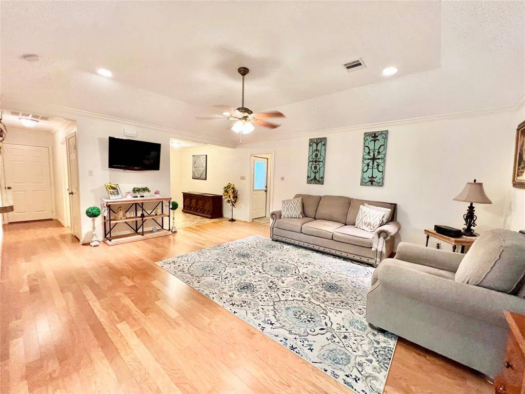 Leaving Kitchen area and going across the living room to the primary suite. On the left side you can see doors that lead to the second and third bedrooms and secondary guest bathroom.
