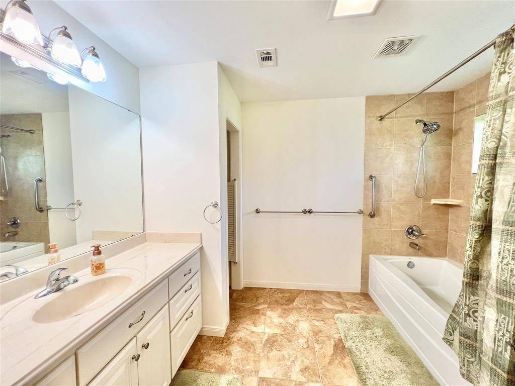 Large en-suite bathroom with privacy doors to the left going to the toilet room.