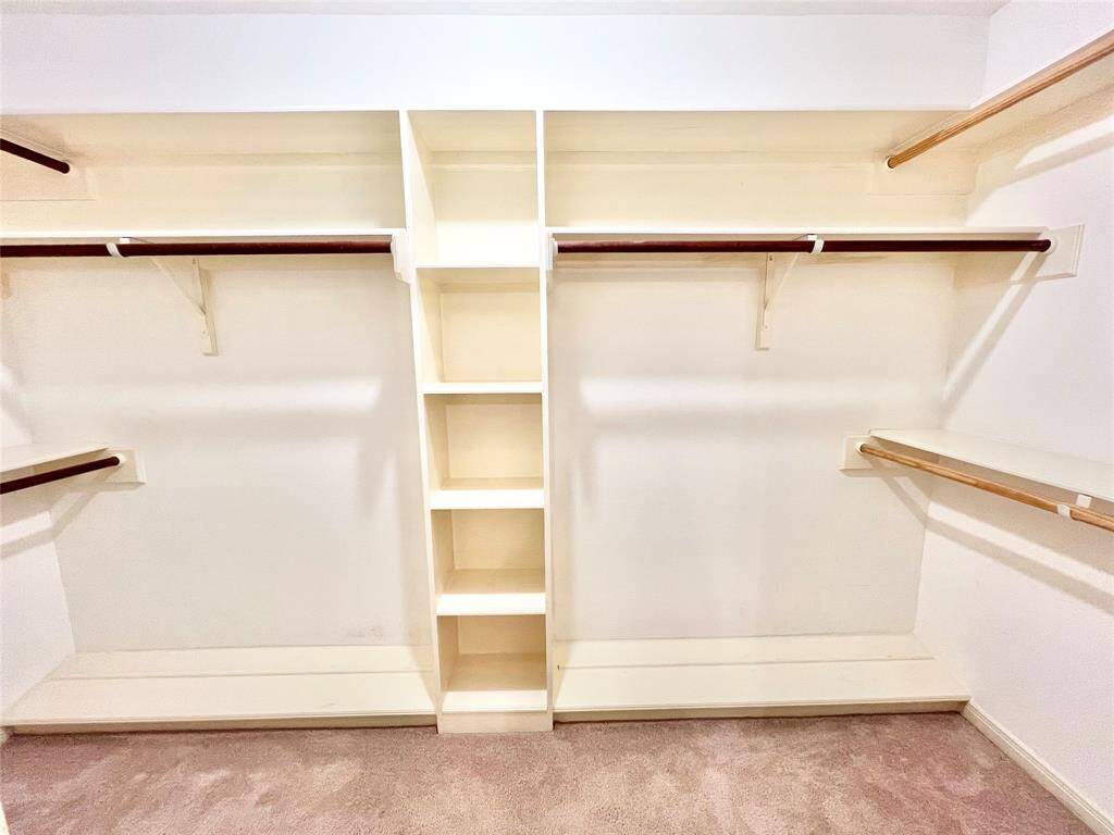 Large primary closet with built-in shoe racks