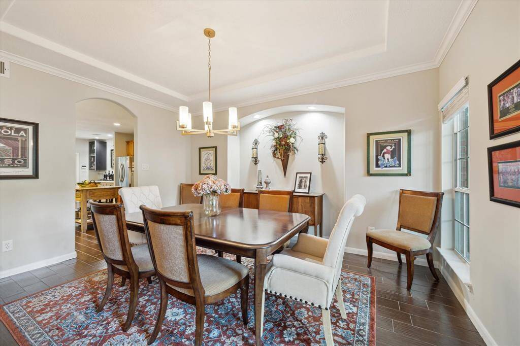 The elegant dining room with warm, neutral tones is enhanced by designer accents and statement finishes.