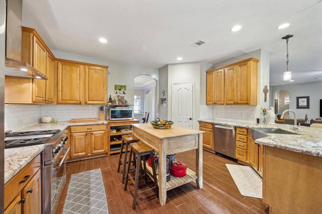 Breakfast bar seating adds functionality, while recessed lighting and an updated backsplash enhance the space.