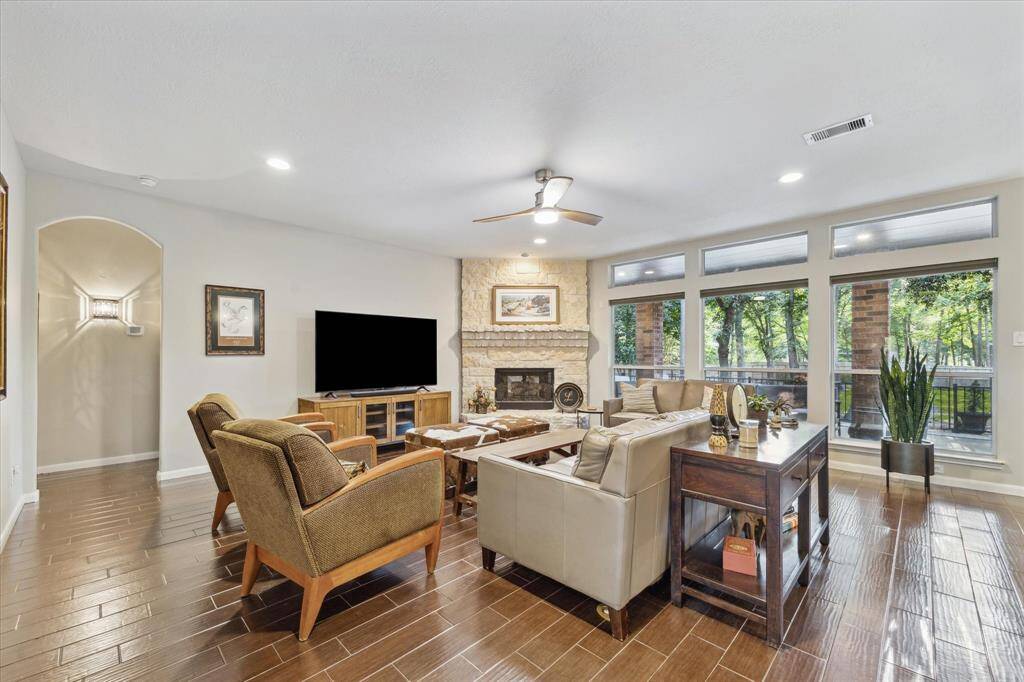 Gather in the living room around a stunning stone fireplace, seamlessly connected to the kitchen.