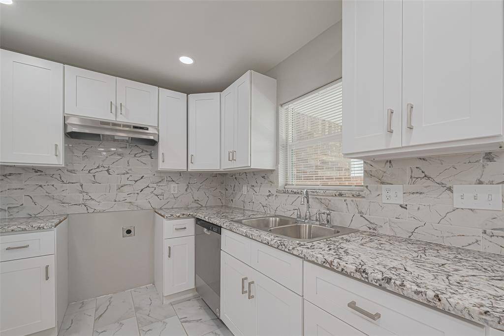 Coordinated gray and white tones blend across the backsplash and countertops, creating a sleek and modern kitchen atmosphere.