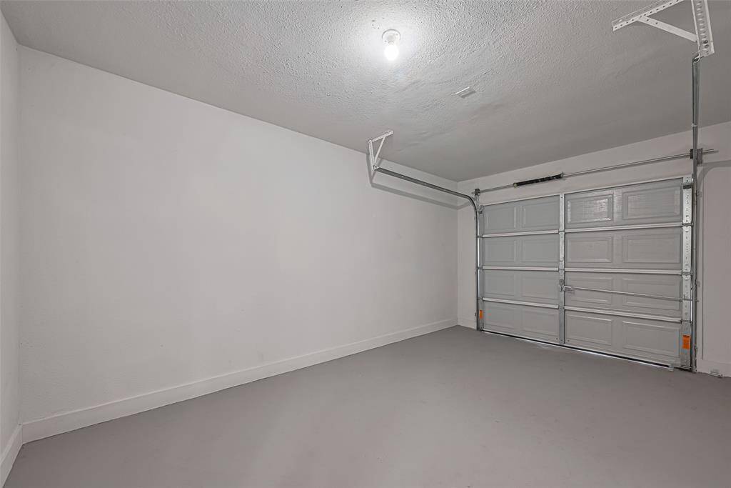 A look inside the one-car attached garage reveals a clean, well-maintained space perfect for storage or a workshop setup.