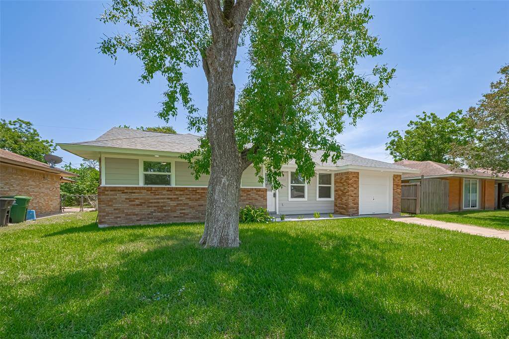 This shot captures the lush front lawn, including a mature tree that offers charm and shade.