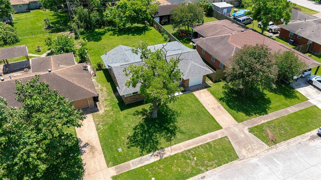 This elevated front view captures the long driveway, neat walkways, and a clear look at the lot’s generous size.
