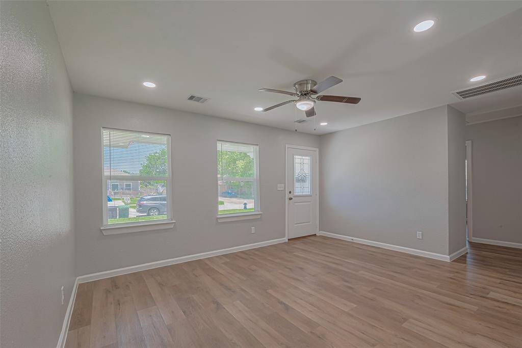 Step through the front door into a bright and welcoming living space, where large windows bring in natural light.