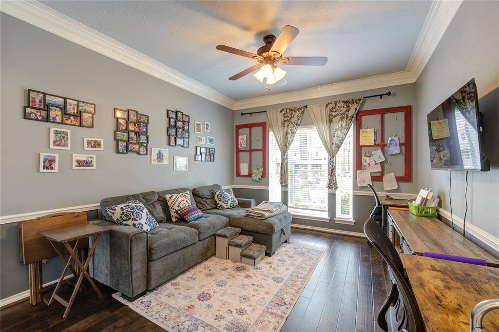 This room is currently used as an office but could be used as an exercise room or game room. Elegant crown molding, a ceiling fan, and ample natural light from the large windows is great for all types of use.