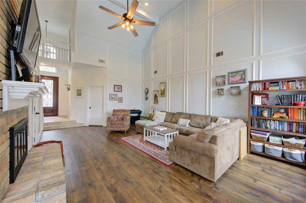 The elegant luxury vinyl plank flooring in the Family Room adds charm, while built-in bookshelves and large windows enhance the space with natural light. Also note the nice wall picture molding.