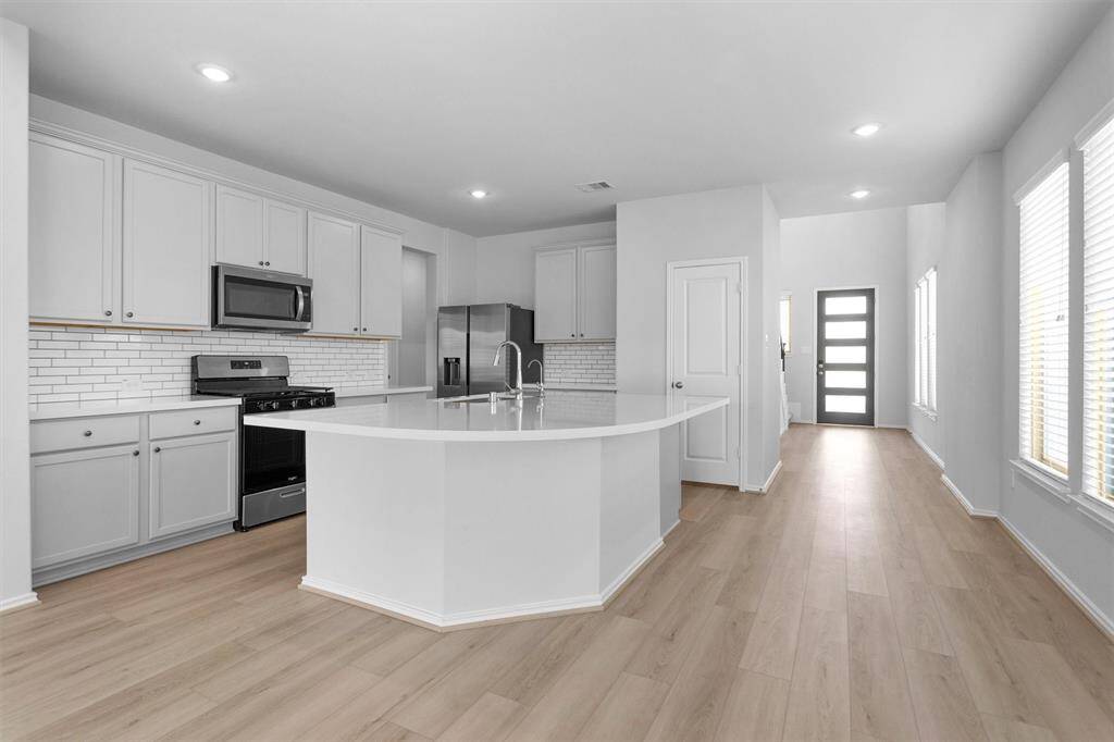 The Kitchen features an upgraded Kitchen Cabinet Style with Painted Cabinets and Island and Countertop with Quartz finish.