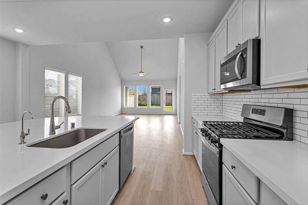 The Kitchen has beautiful light-colored finishes including upgraded Kitchen backsplash with custom color grout.