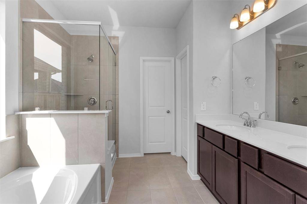 The Primary Bathroom features dual sinks, a large soaking tub, and a separate walk-in shower.