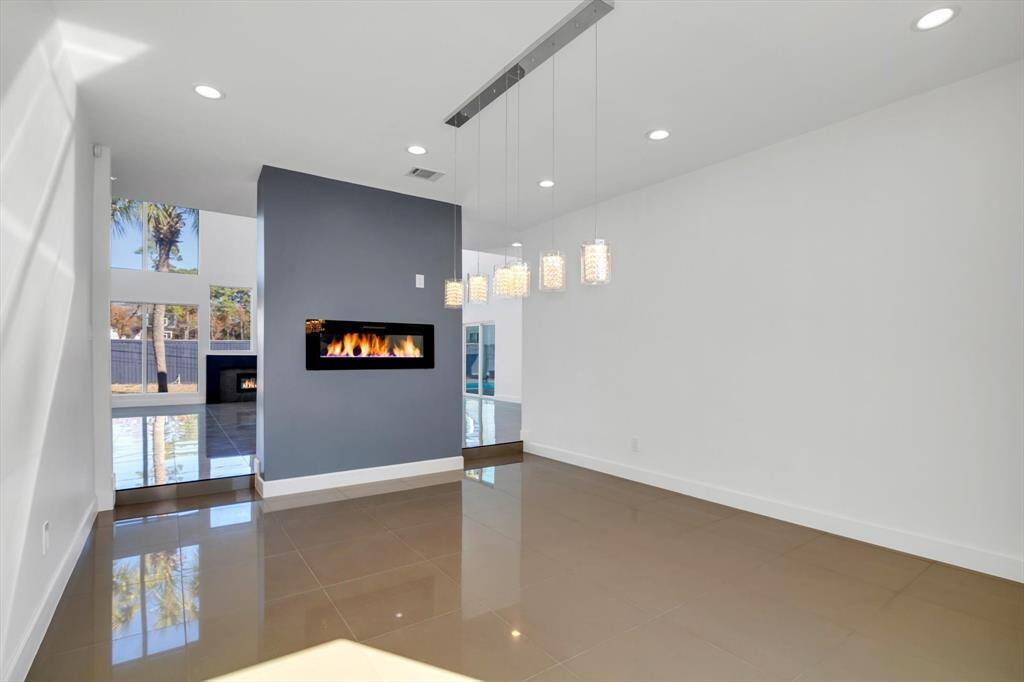 Discover this stunning, single-story modern home with a sleek dark roof and crisp white exterior, nestled in a serene suburban neighborhood. Surrounded by lush greenery and mature trees, it offers a private backyard complete with a tennis court. Enjoy the tranquility of a well-maintained, cohesive community.