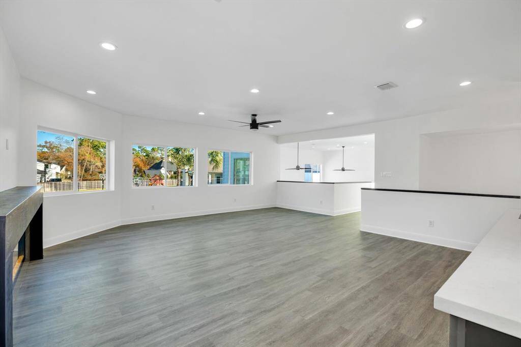 Bright and spacious game room with large windows, sleek flooring, and a cozy fireplace—ideal for entertainment and relaxation.