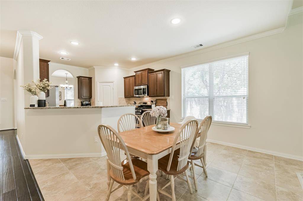Crown molding and tile floors highlight the kitchen, breakfast and den.
