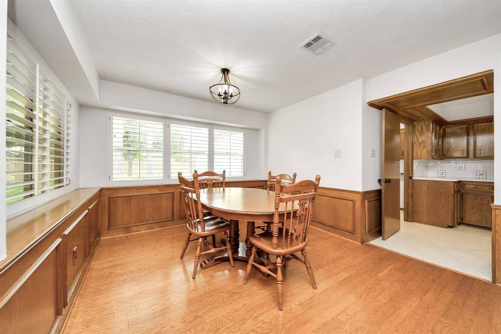 Open and bright breakfast room overlooking large covered back patio and yard