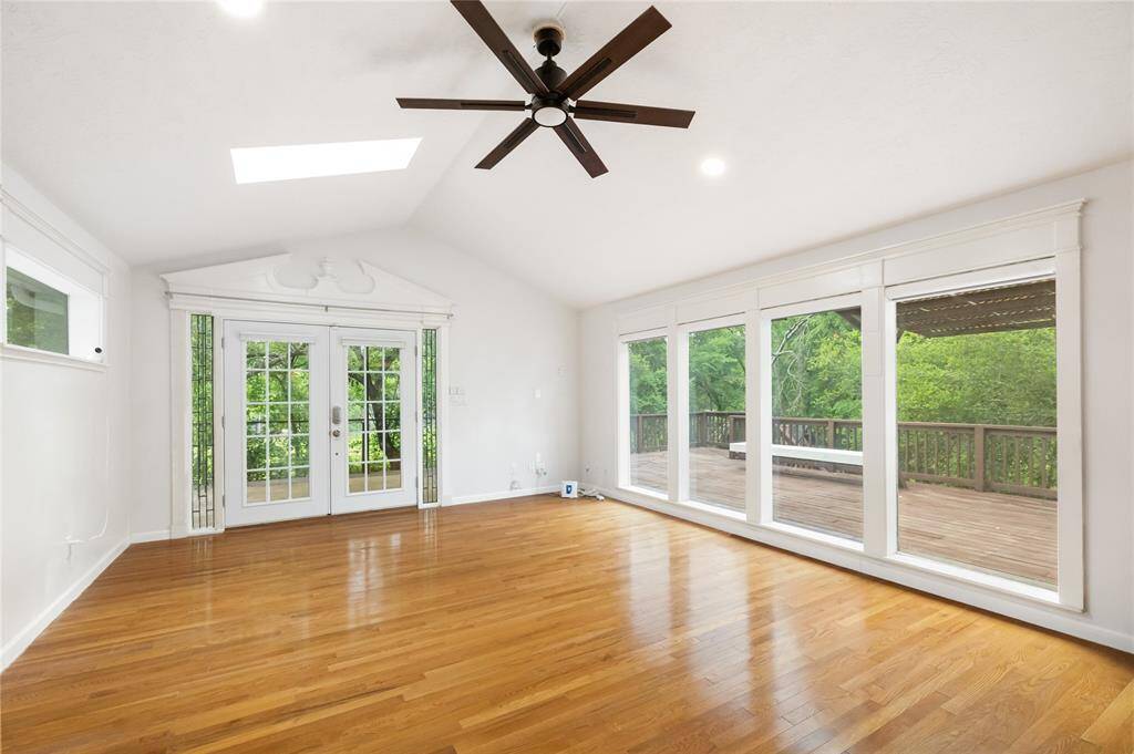 This expansive flex room is bathed in natural light, with wall-to-wall windows that frame serene views of the surrounding trees. Step out to your private deck or stay inside and enjoy the versatility—ideal for a game room, creative space, library, or hosting your favorite gatherings.