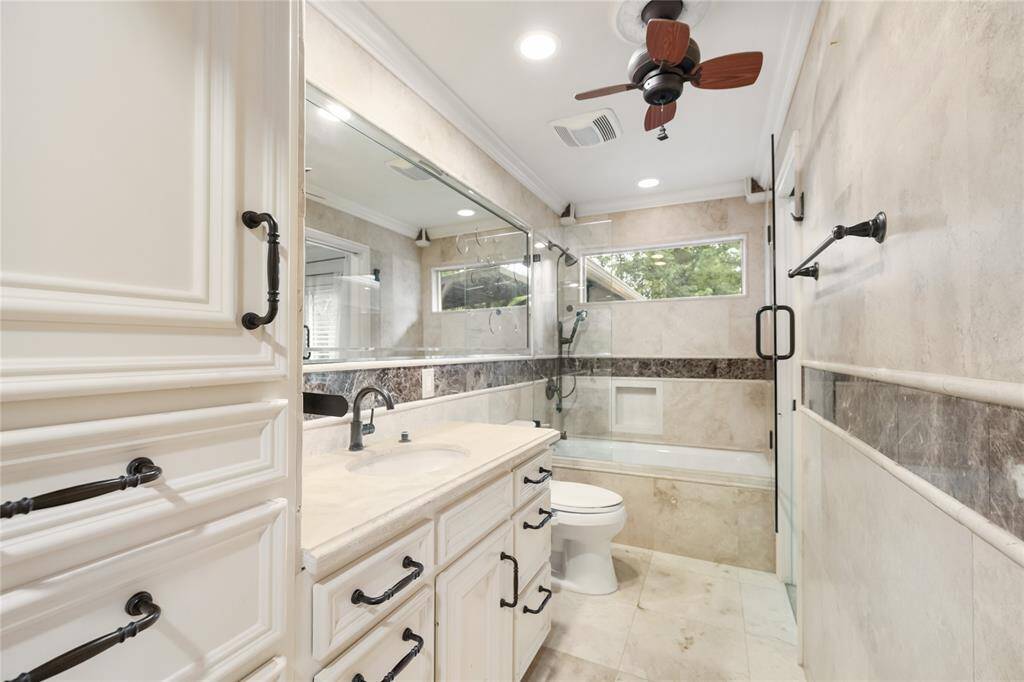 Wrapped in floor-to-ceiling travertine, the primary bath combines spa-like finishes with everyday function. Generous cabinetry offers plenty of storage, while the tub/shower combo is perfect for winding down or getting going.