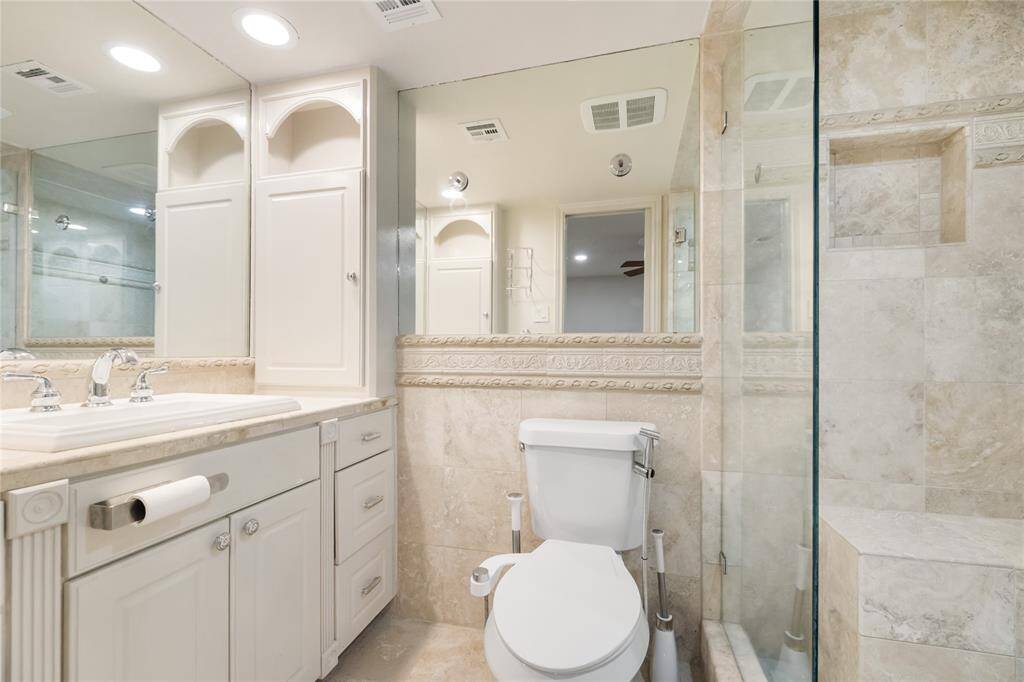 With ornate detailing, mirrored accents, and floor-to-ceiling travertine, this secondary bath has style and substance. There’s also plenty of storage for all the essentials.
