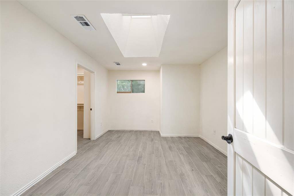 This sun-filled secondary bedroom includes a spacious walk-in closet, making it a restful retreat for guests or family.