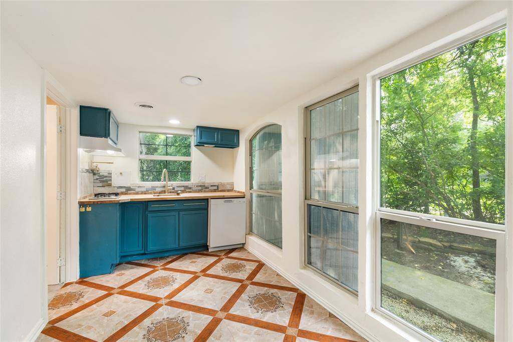 Located within the primary suite, this cozy kitchenette adds convenience and character with distinctive tilework, large windows, and peaceful treetop views that bring the outdoors in.