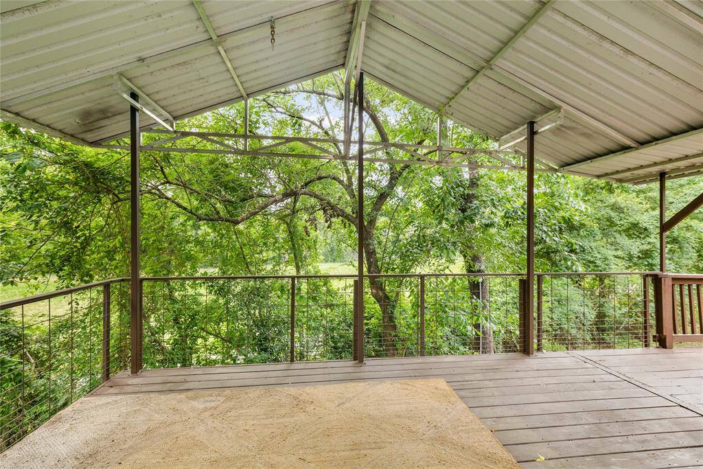 Enjoy your morning coffee or evening unwind on the covered upper deck, surrounded by lush landscape. A peaceful extension of the living space, perfect for relaxing or entertaining.