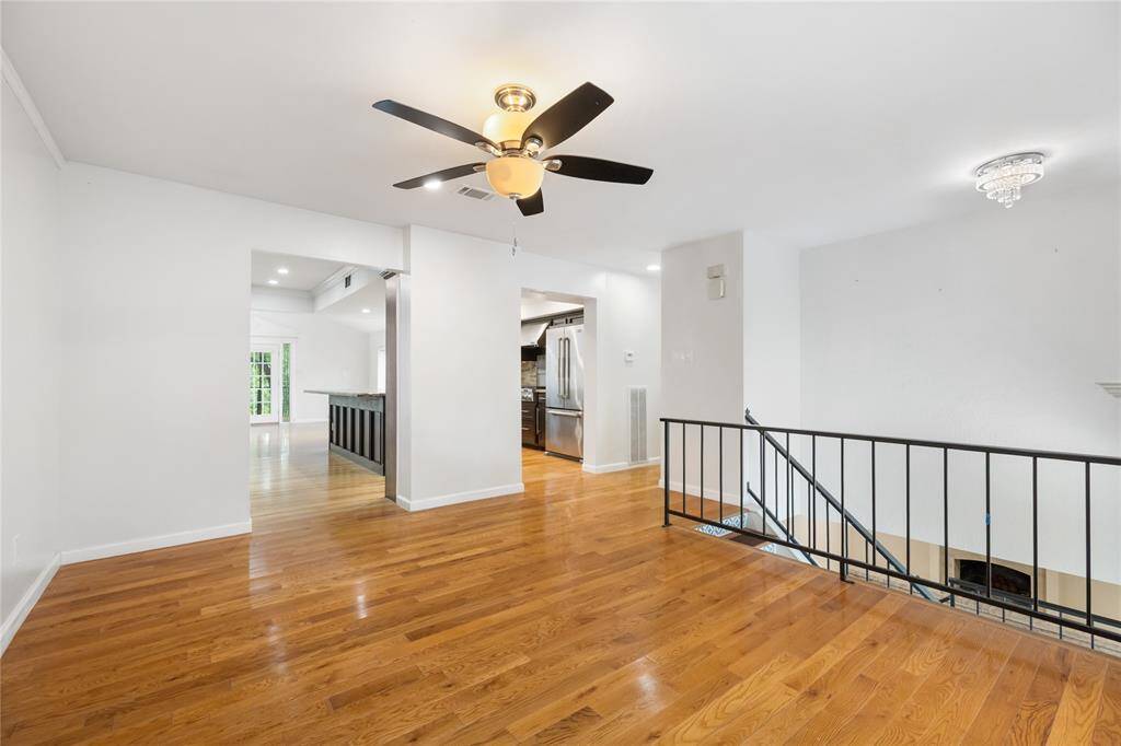 The open layout offers a sneak peek into the gourmet kitchen ahead—dark cabinetry, marble countertops, and stainless steel appliances set the tone for both style and function.