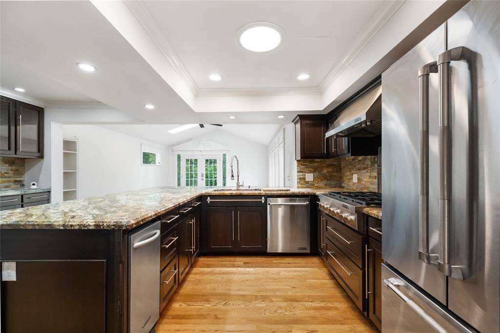 Expansive countertops, stainless steel appliances, and a convenient breakfast bar make everyday meals and entertaining a breeze. Double ovens, windowed upper cabinets, a walk-in pantry, and deep pots-and-pans drawers offer all the storage and tools you need.