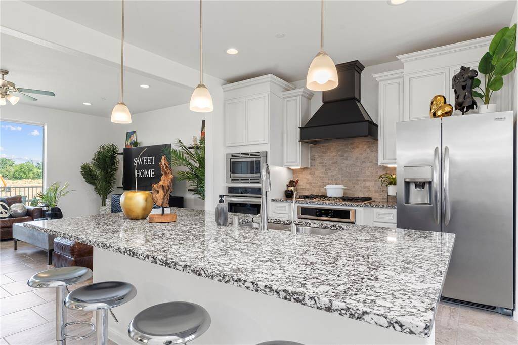 Serious cooks will appreciate the double ovens, tall gorgeous custom cabinetry, and a large center island for added prep space. Ample natural light and designer finishes add elegance to this hardworking space.