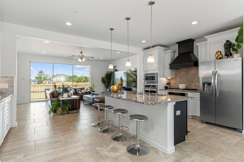 Upstairs retreat to your serene primary suite, complete with a dramatic tray ceiling, ceiling fan, and plenty of natural light. French doors open to the balcony, inviting fresh air and scenic views inside.