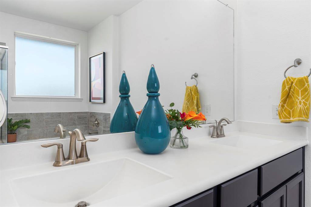 The oversized walk-in shower features floor-to-ceiling tile, a built-in bench, and a stylish mosaic niche—perfect for comfort and convenience in your daily self-care routine.