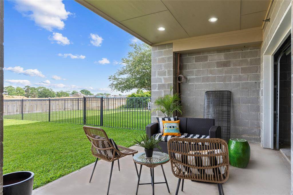 Take in the full scale of the back exterior showcasing individually fenced yards, balconies on each level, and a well-kept common area. Built for comfort, community, and easy outdoor living.