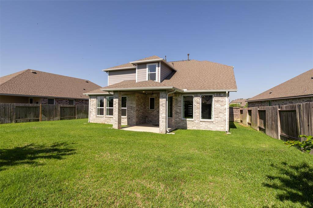 Covered back porch with fan ideal for grill and entertainment!