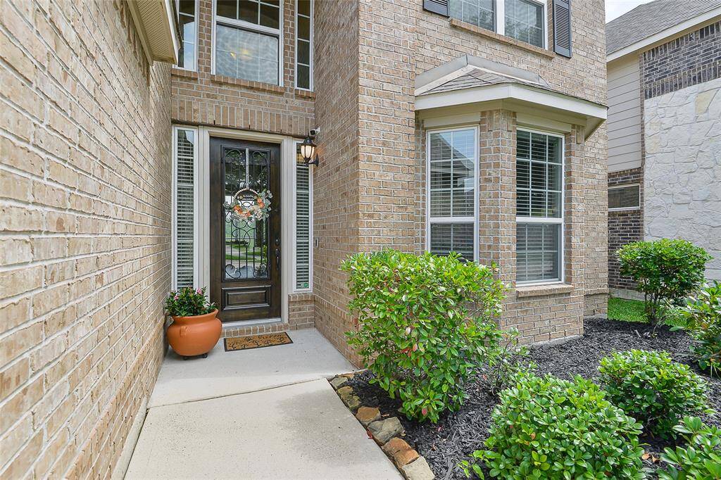 The upgraded entry makes a lasting first impression, featuring a stunning front door crafted from rich wood, accented with wrought iron and decorative glass—blending elegance, security, and natural light.