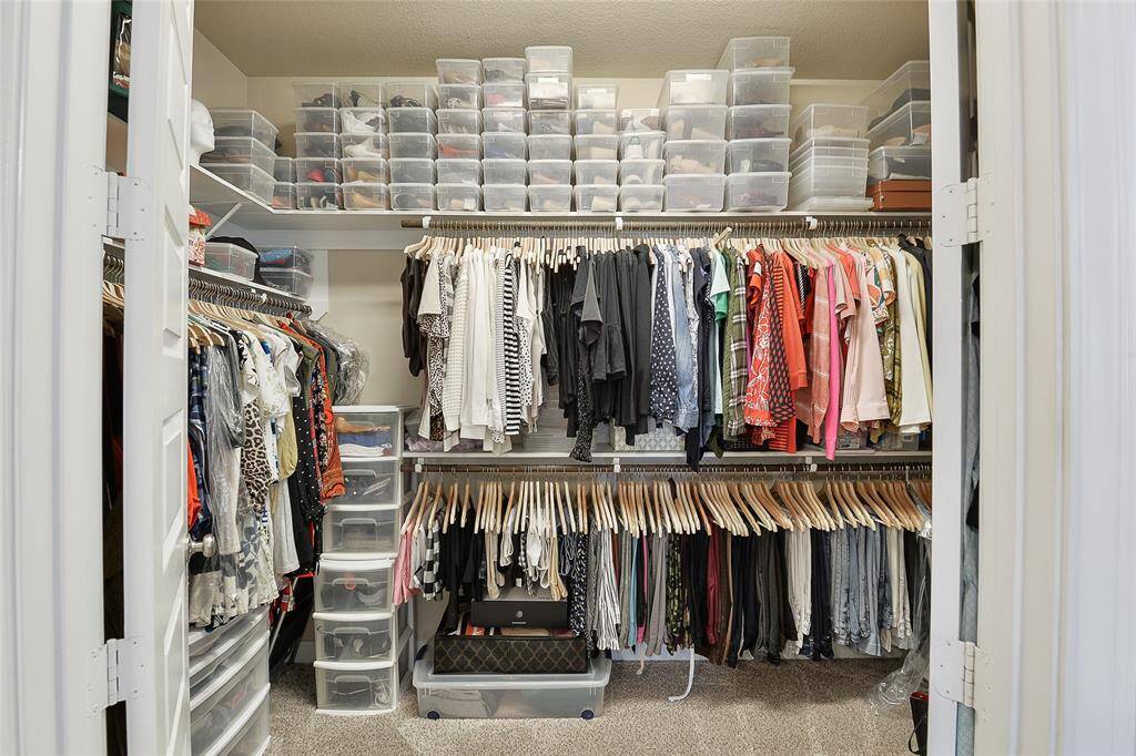 The primary walk-in closet features high ceilings and ample space, perfectly designed to accommodate all your essentials with room to spare for added organization.