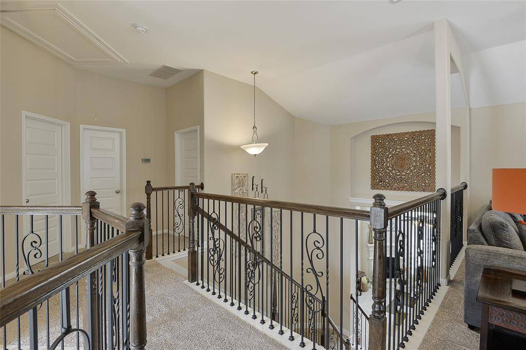 The open staircase on the second floor offers a stunning vantage point, providing a beautiful overlook into the living area and grand foyer—adding architectural elegance and a sense of connection throughout the home.