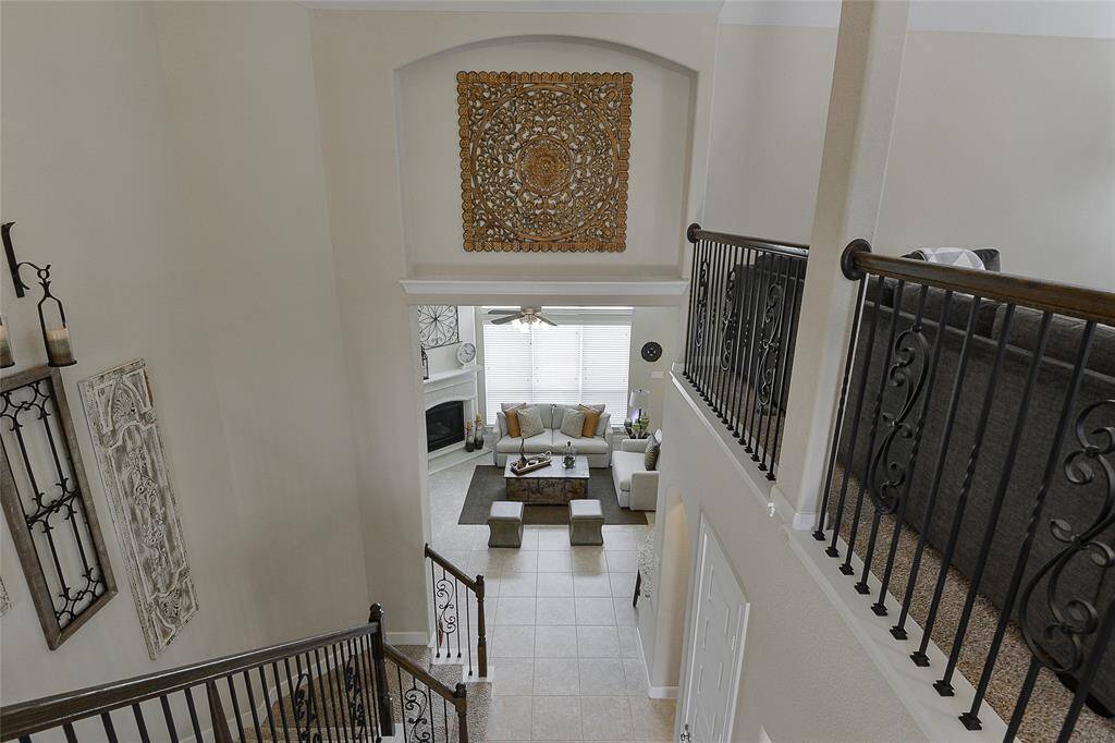 The open staircase on the second floor offers a stunning vantage point, providing a beautiful overlook into the living area and grand foyer—adding architectural elegance and a sense of connection throughout the home.