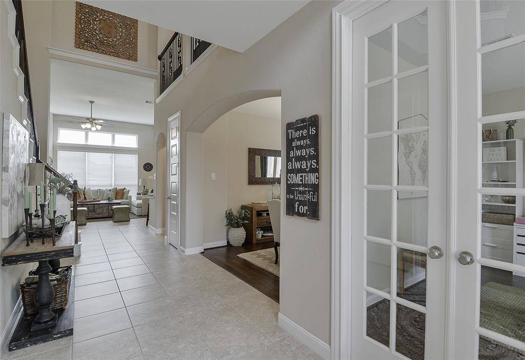 Step into an open entryway that soars with a stunning 20-foot ceiling, creating a grand and airy welcome that immediately elevates this home and the elegance it offers.