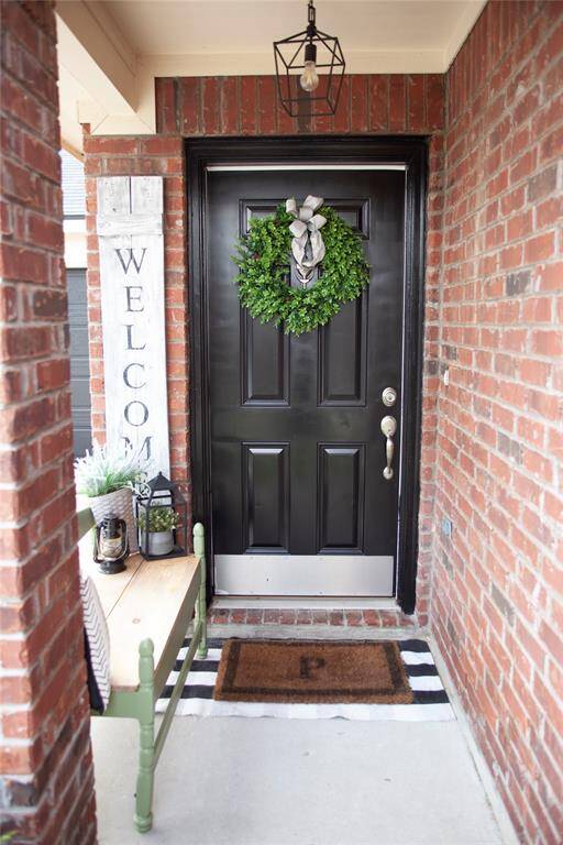 Step up to the charming covered entry featuring a classic brick exterior, elegant black front door,