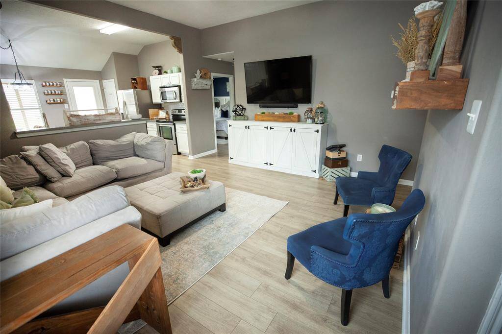 Open-concept layout connects seamlessly to the kitchen, enhancing the flow for entertaining or everyday living. Natural light pours in through the nearby windows, giving the space an inviting, lived-in feel.