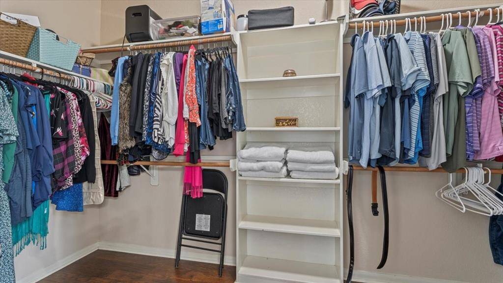 Walk in closet with hardwood floors