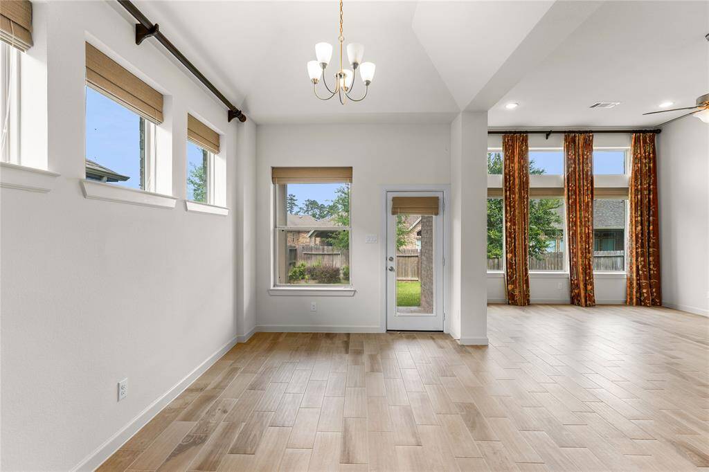 Large windows with woven shades and views of the backyard.