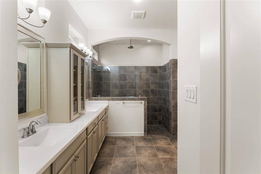 En-suite bath includes dual vanities, a walk-in shower, and a large walk-in closet with built-ins.